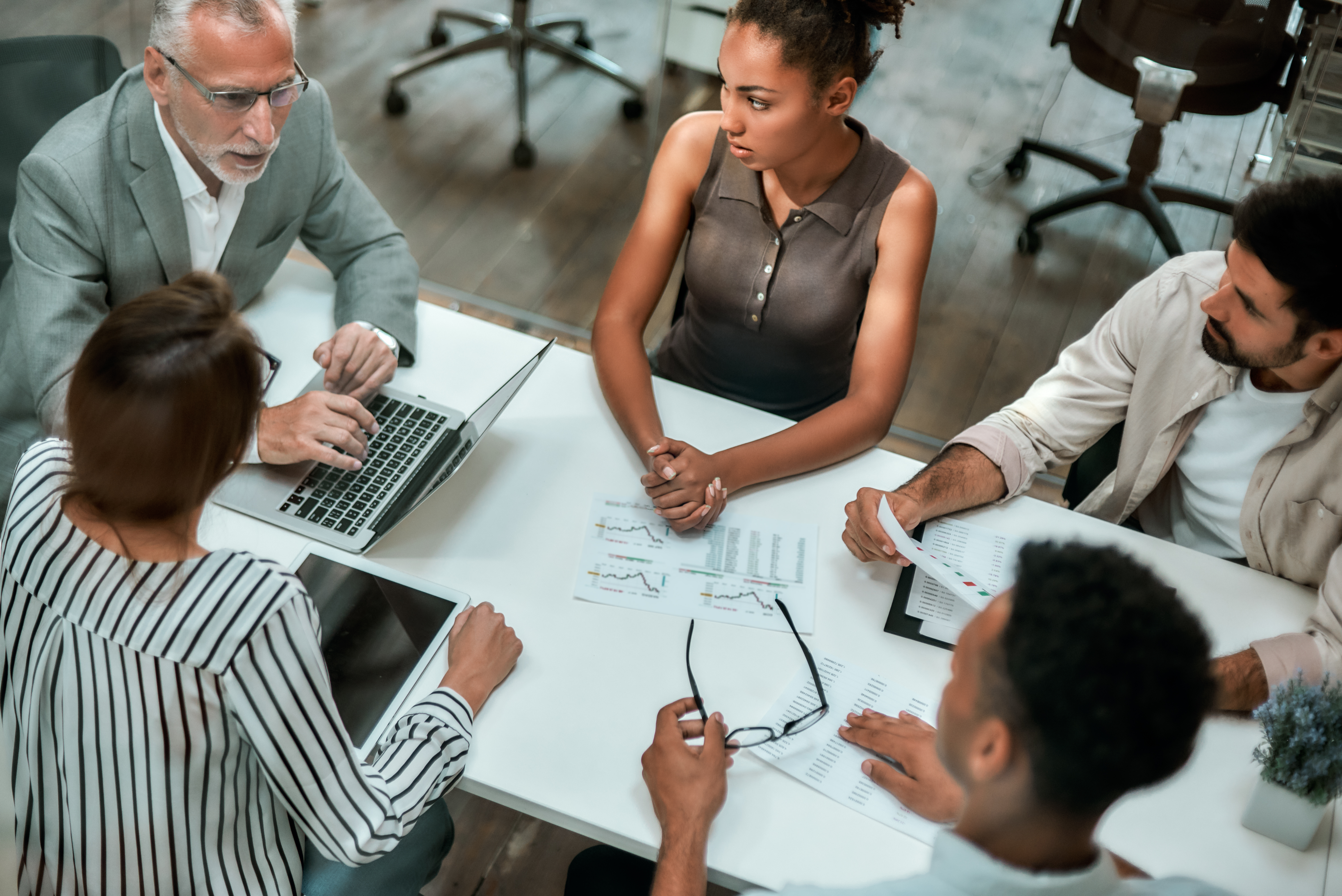 top-view-of-multicultural-team-discussing-business-while-sitting-at-the-office-table-together.jpg